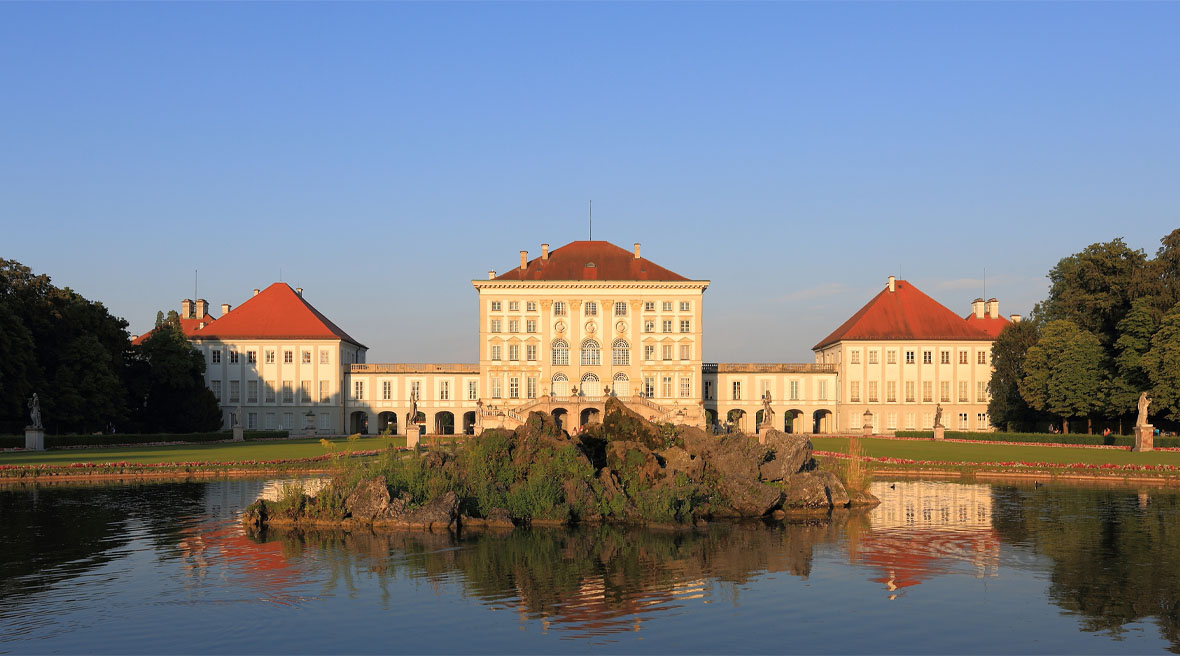 A large chateau with gardens and a lake