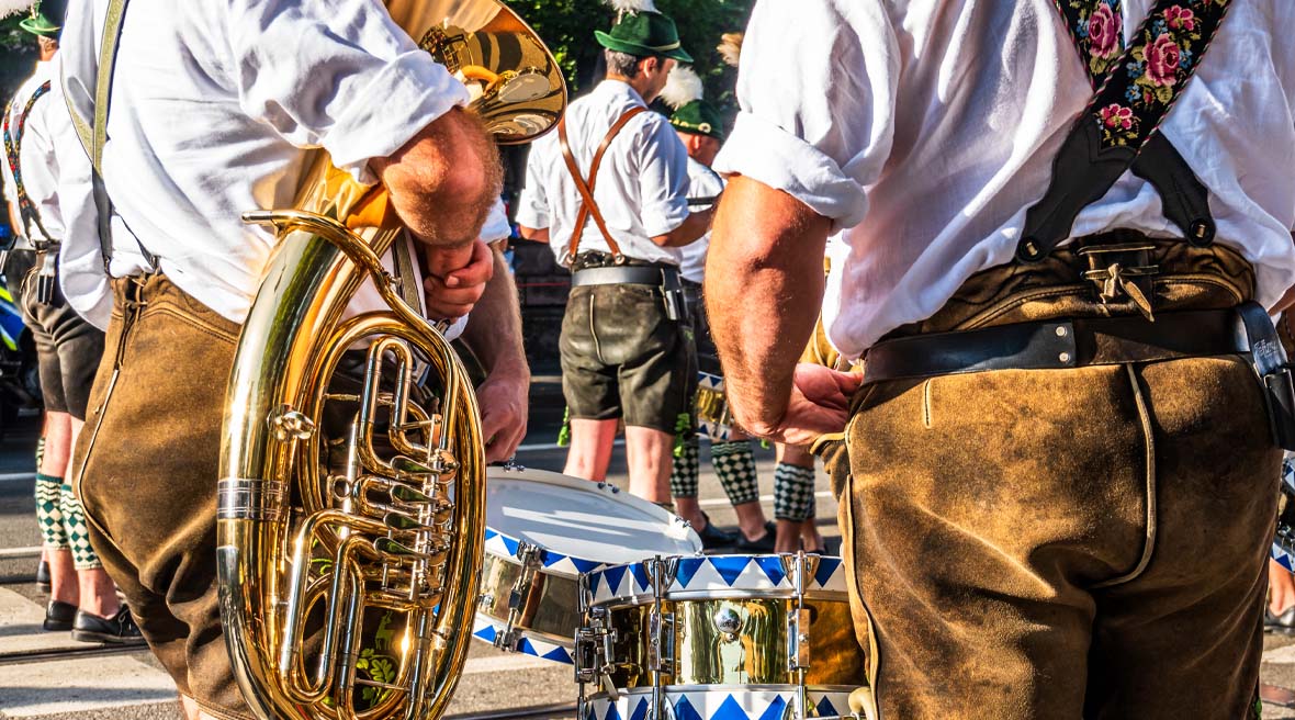 Members of a brass band stand around in the sunshine
